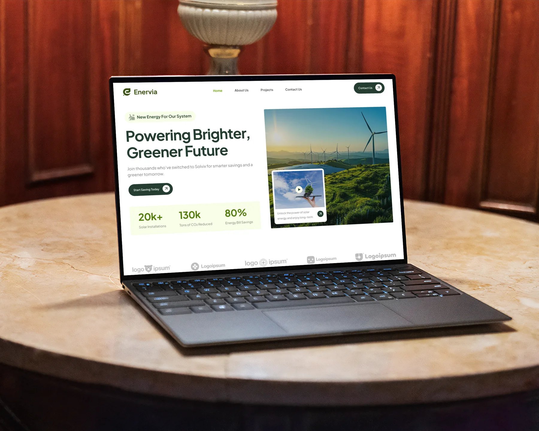 Enervia landing page on a laptop: 'Powering Brighter, Greener Future' hero with wind turbines